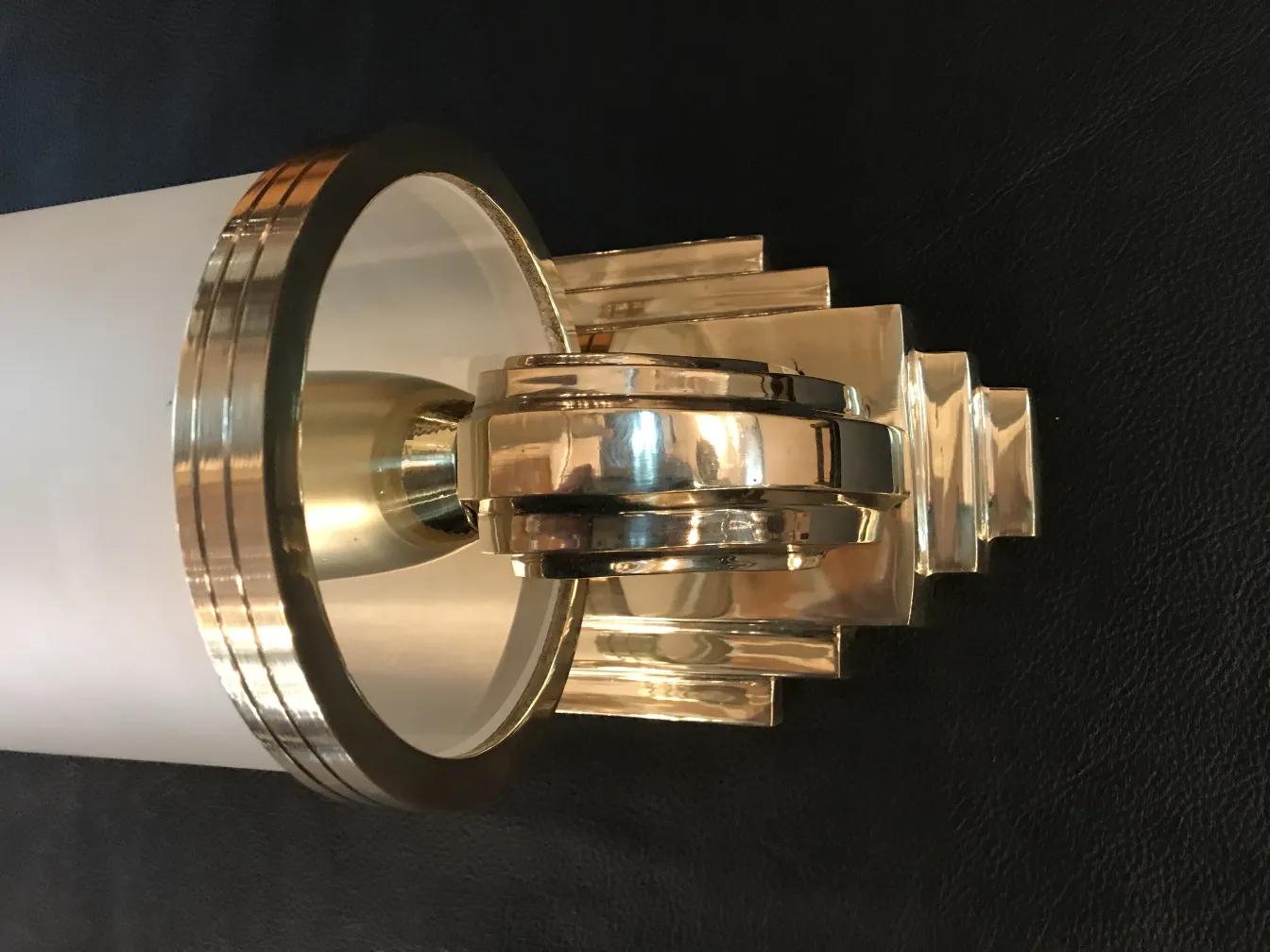 Antique wall sconces in shiny gold and white, featuring elegant design.