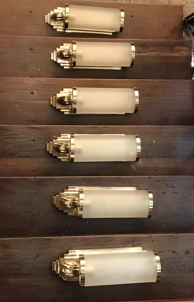 पुरानी सोने की परत और मैट कांच के साथ स्कोनस की जोड़ी, लकड़ी की सीढ़ी को सजाते हैं।