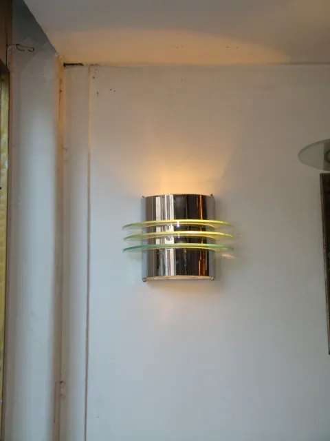 Aplique antiguo de pared con detalles en color amarillento y acabado brillante, iluminando el ambiente.