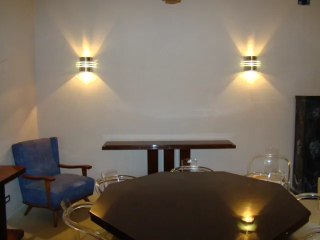 Par de apliques antiguos iluminando una pared desnuda