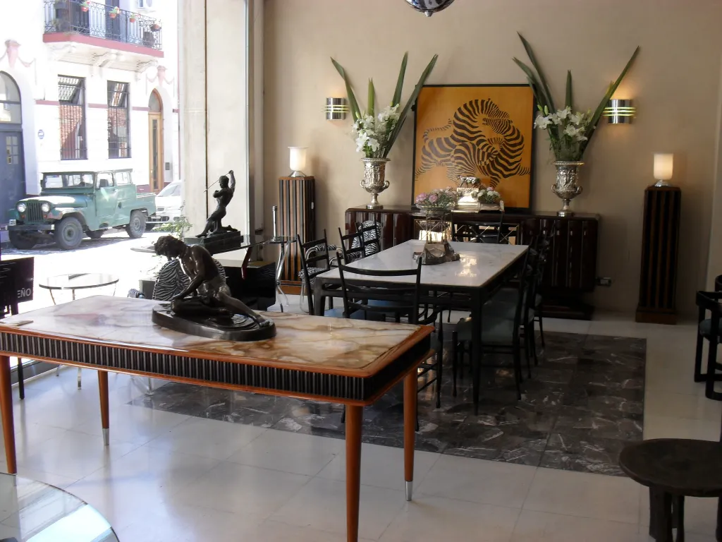 Par de apliques antiguos junto a una mesa de mármol, en una decorada habitación