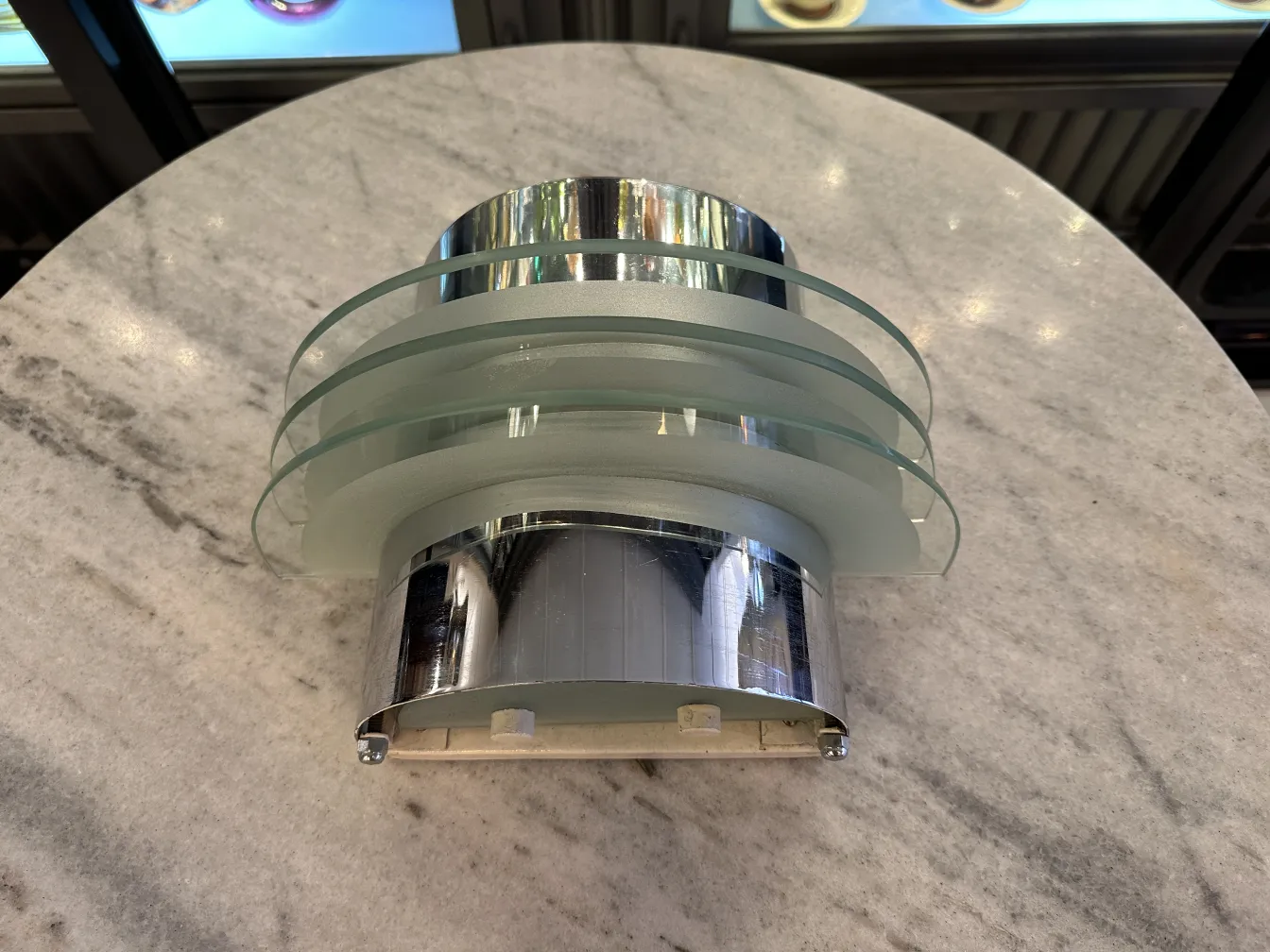Vintage pair of sconces with glass and chrome design on a marble table.