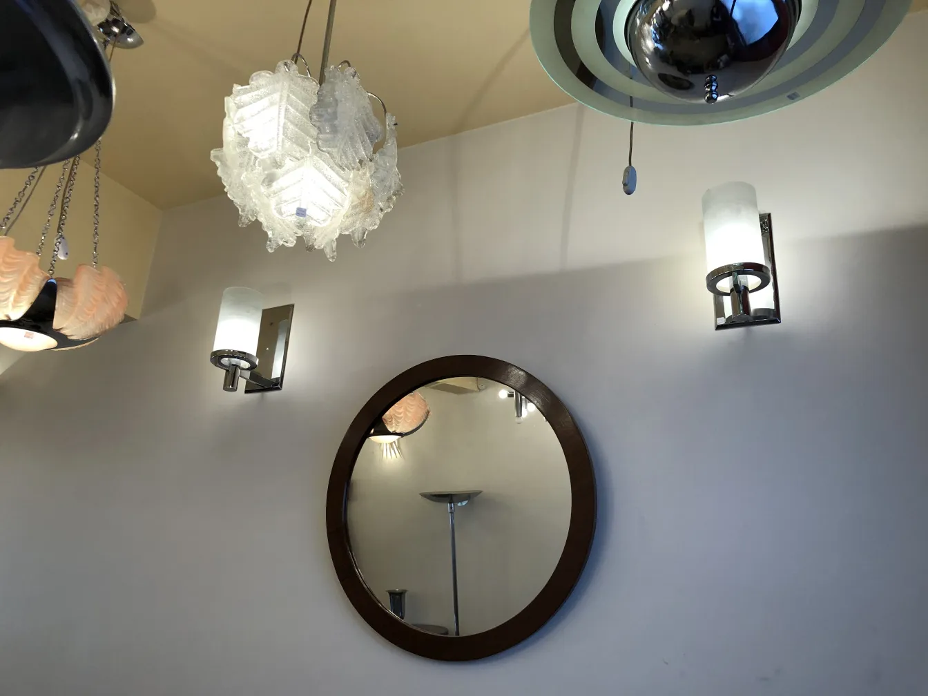 Pair of antique sconces with soft light on the wall, next to a mirror.