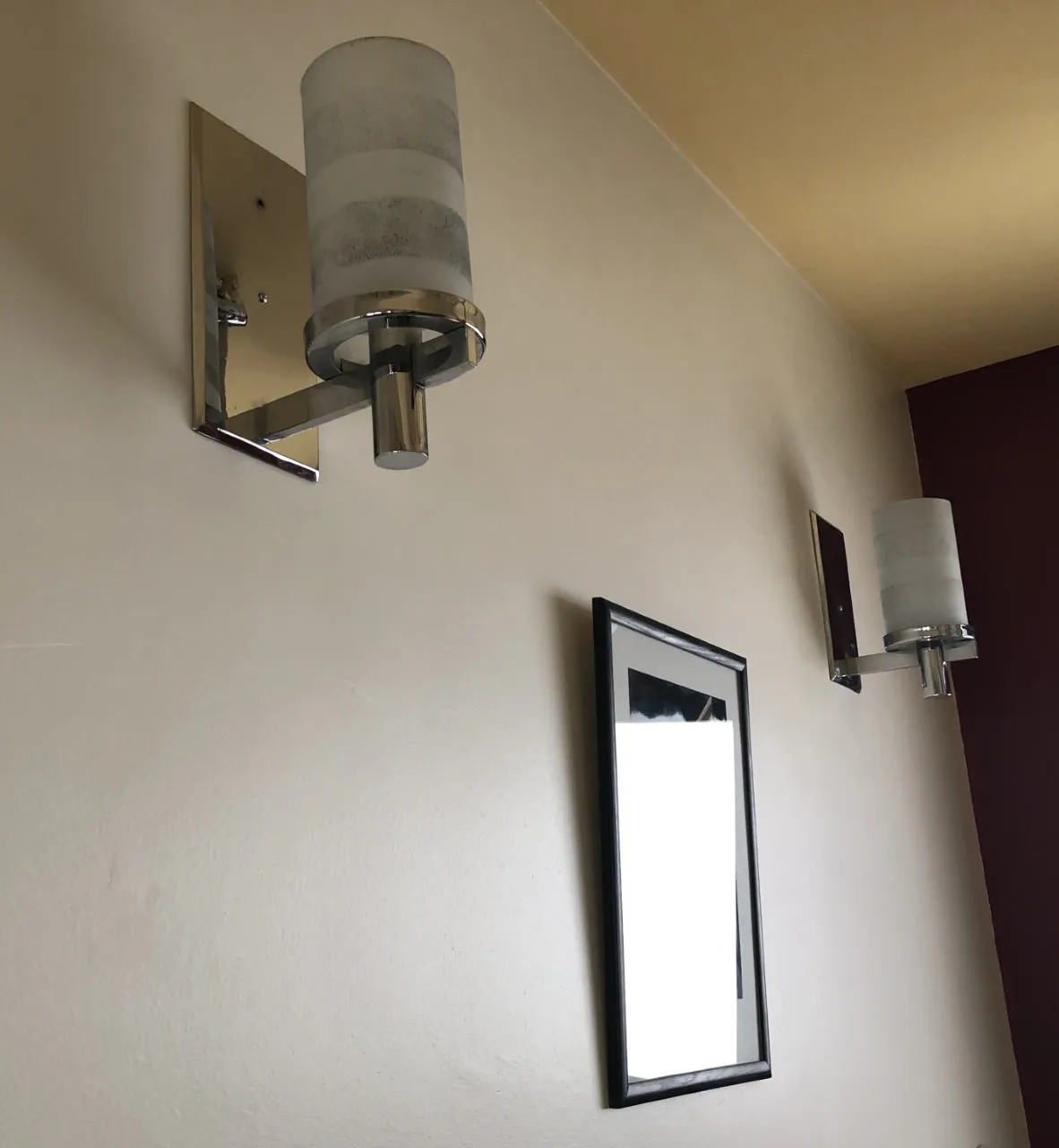 Par de luminárias de parede com abajur de vidro em parede decorativa