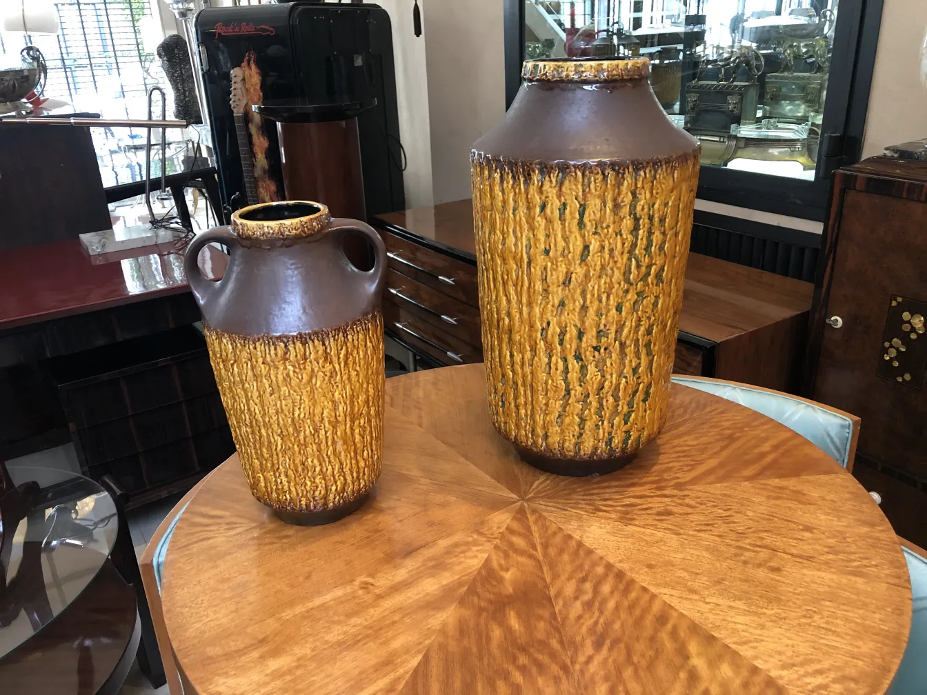 Deux vases décoratifs en céramique ancienne aux tons marron et jaune sur une table