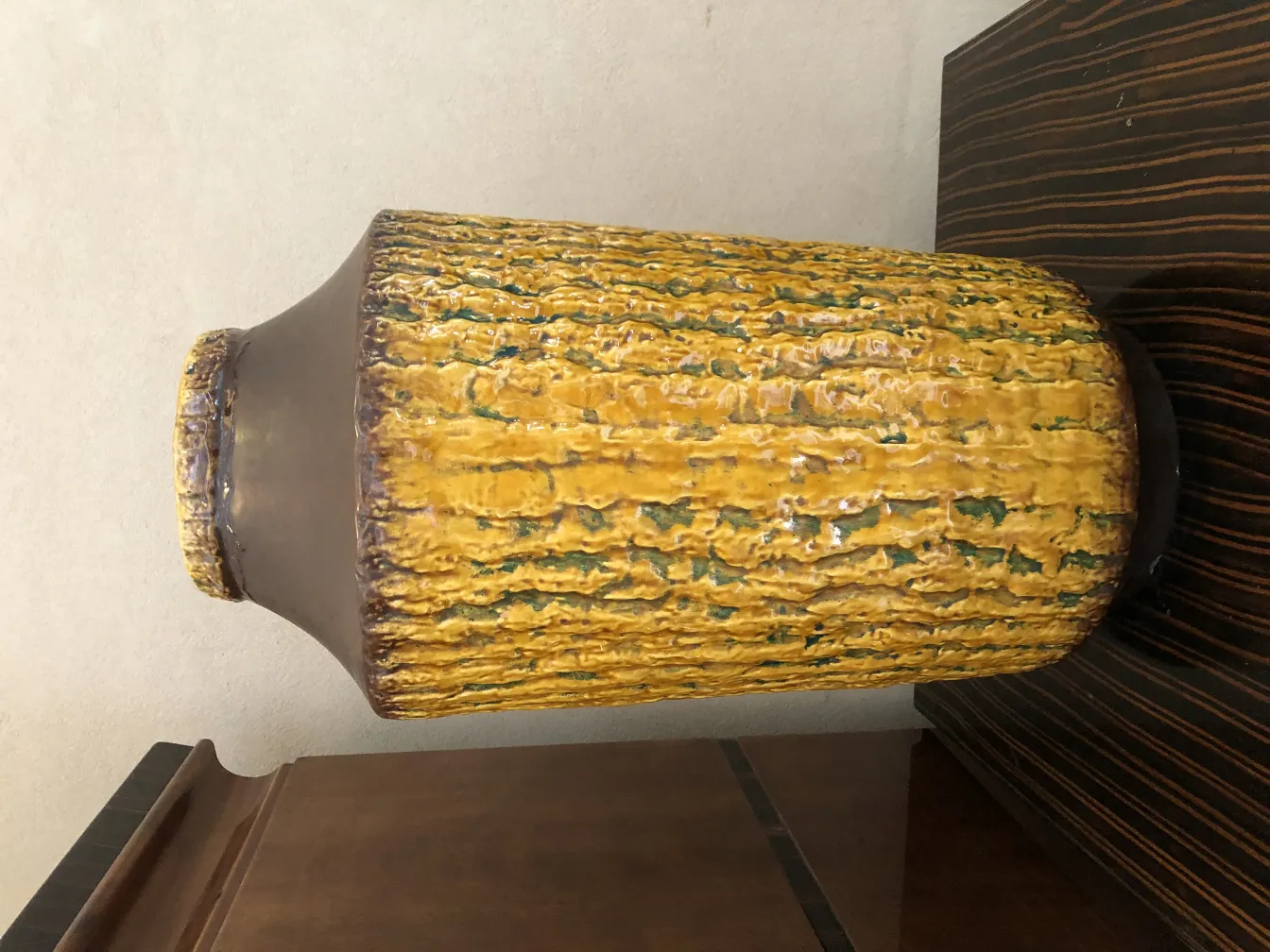 Vase en céramique ancienne avec texture jaune et verte.