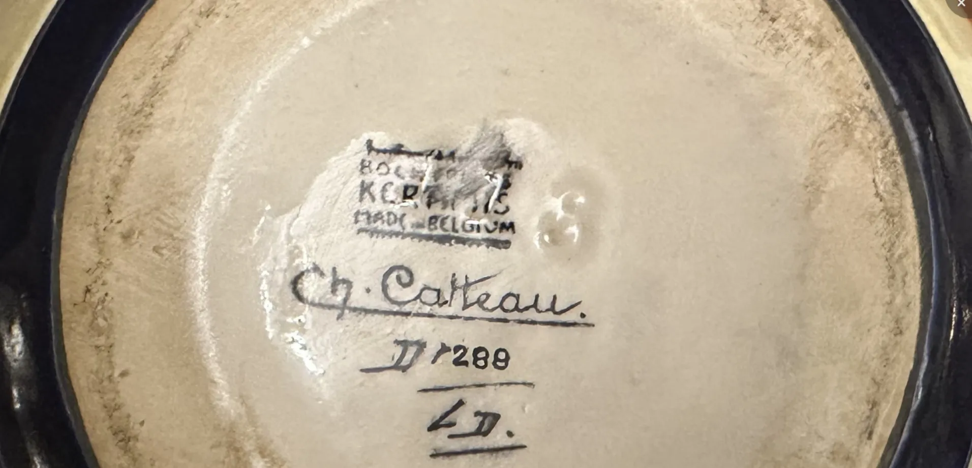 Dessous de céramique belge ancienne avec détail de la signature Ch. Catteau
