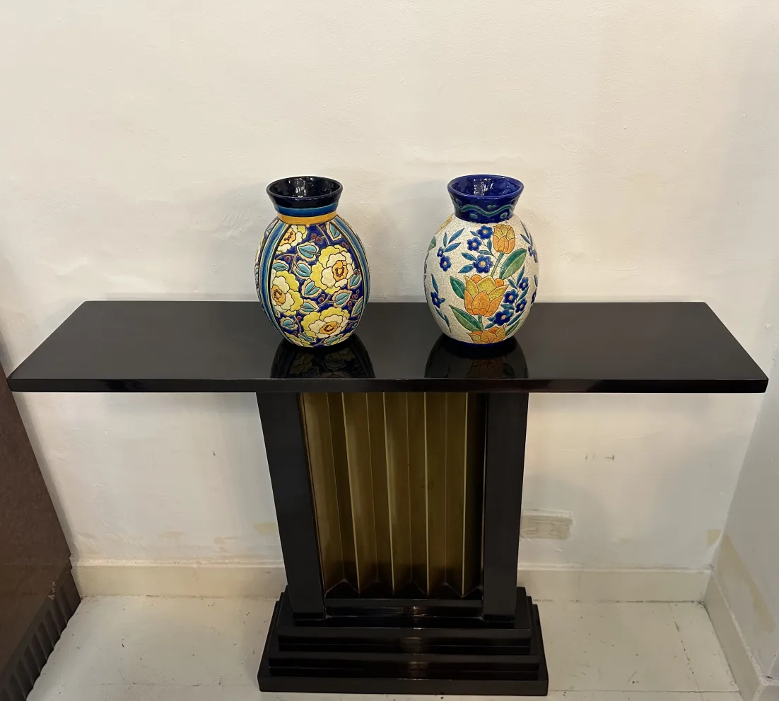 Antique ceramic vases with floral designs on a table.