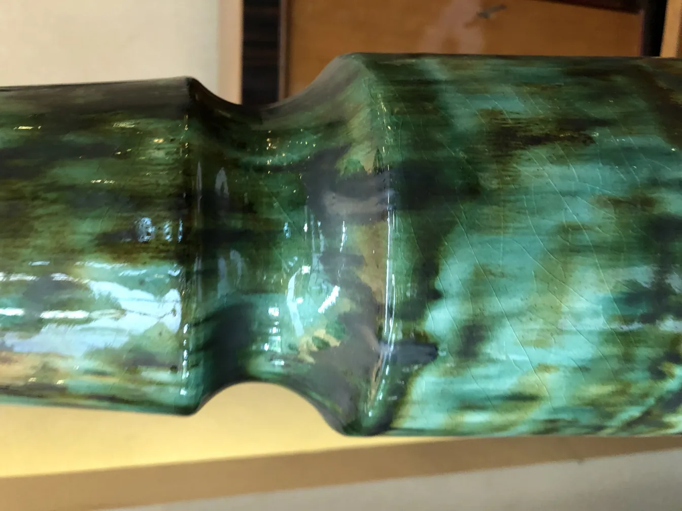 Detalhe de cerâmica antiga em verde brilhante, visíveis detalhes.