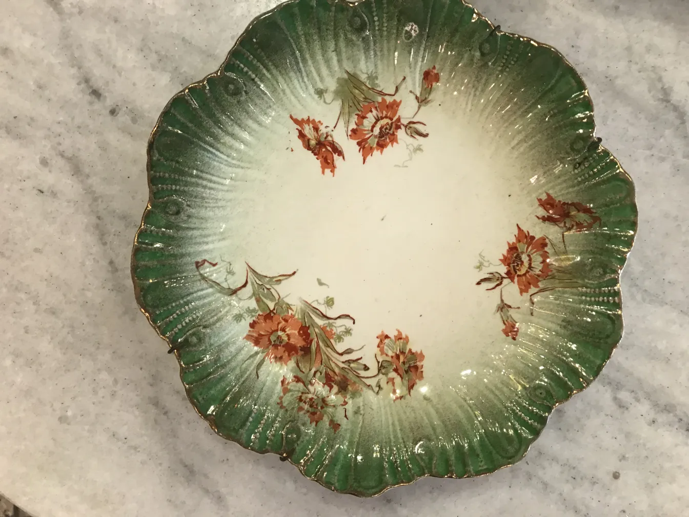 Assiette ancienne en céramique avec fleurs en relief et bord vert