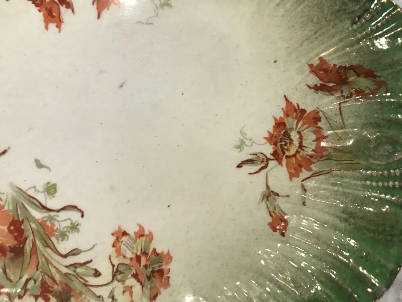 Antique ceramic plate with floral decoration in warm colors