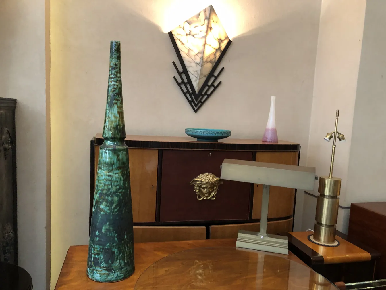 Vaso antigo em cerâmica verde esculpida em um ambiente elegante.