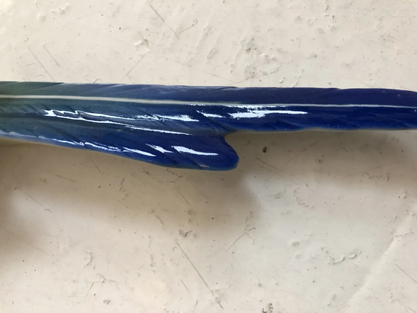 Antiga cerâmica azul com um design fluido em um fundo claro.