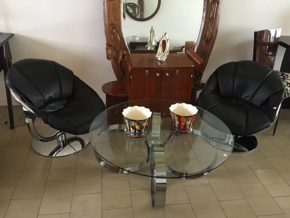 Dos macetas de cerámica antigua sobre una mesa de vidrio, en un entorno moderno.