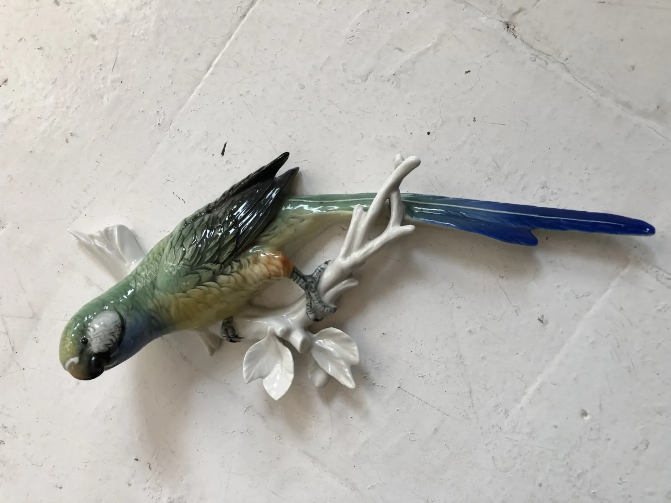 枝に留まる色とりどりの鳥の古代の陶器の彫刻。