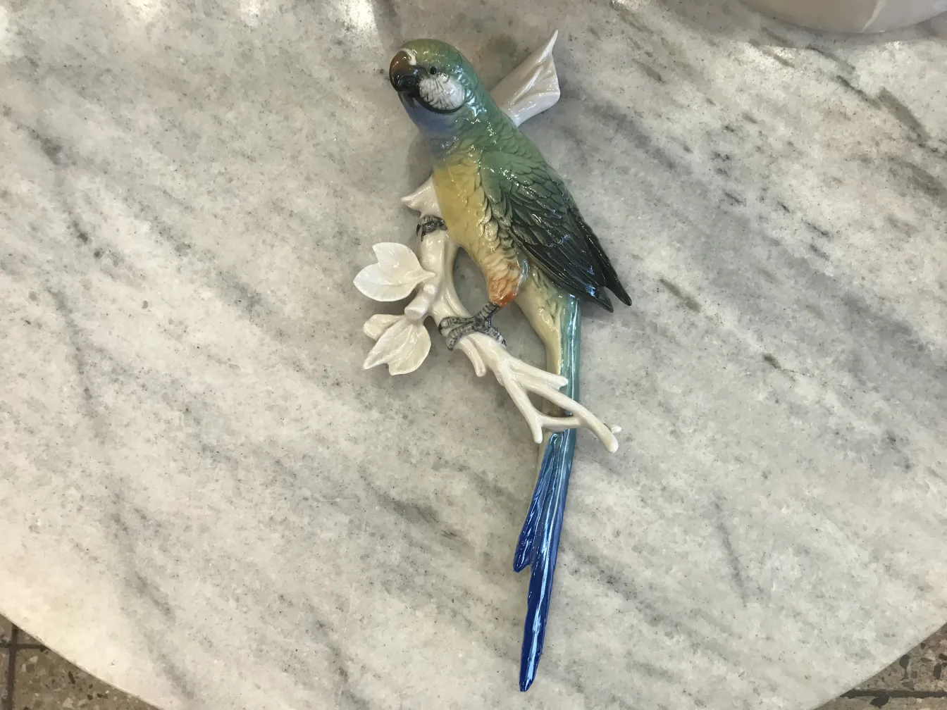scultura in ceramica antica di Karl Ens con un uccello colorato su un ramo
