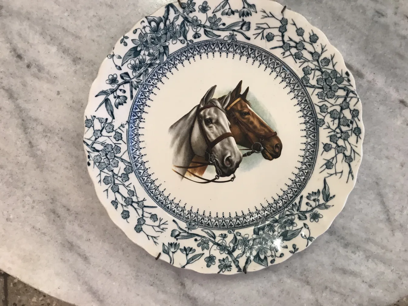 Piatto in ceramica antica con due cavalli al centro.
