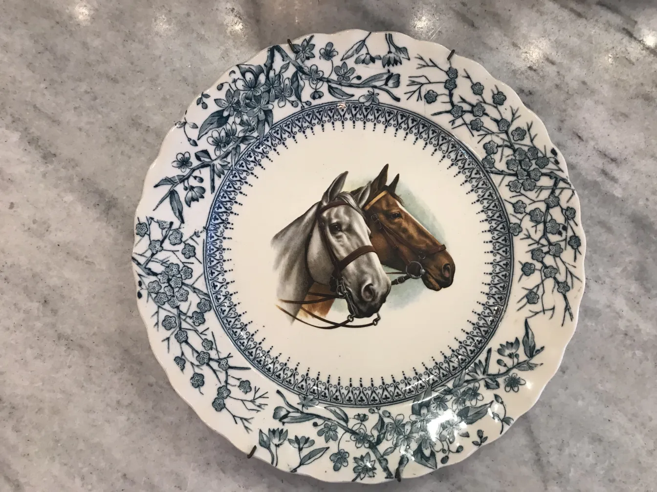 Prato de cerâmica antiga com imagem de dois cavalos em perfil