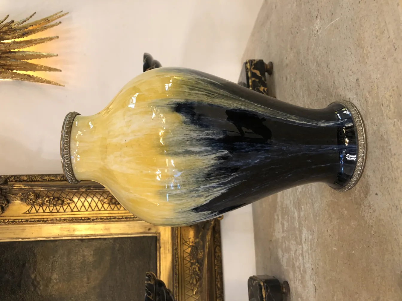 Vase en céramique antique de couleur noire et jaune, avec un fond doré.