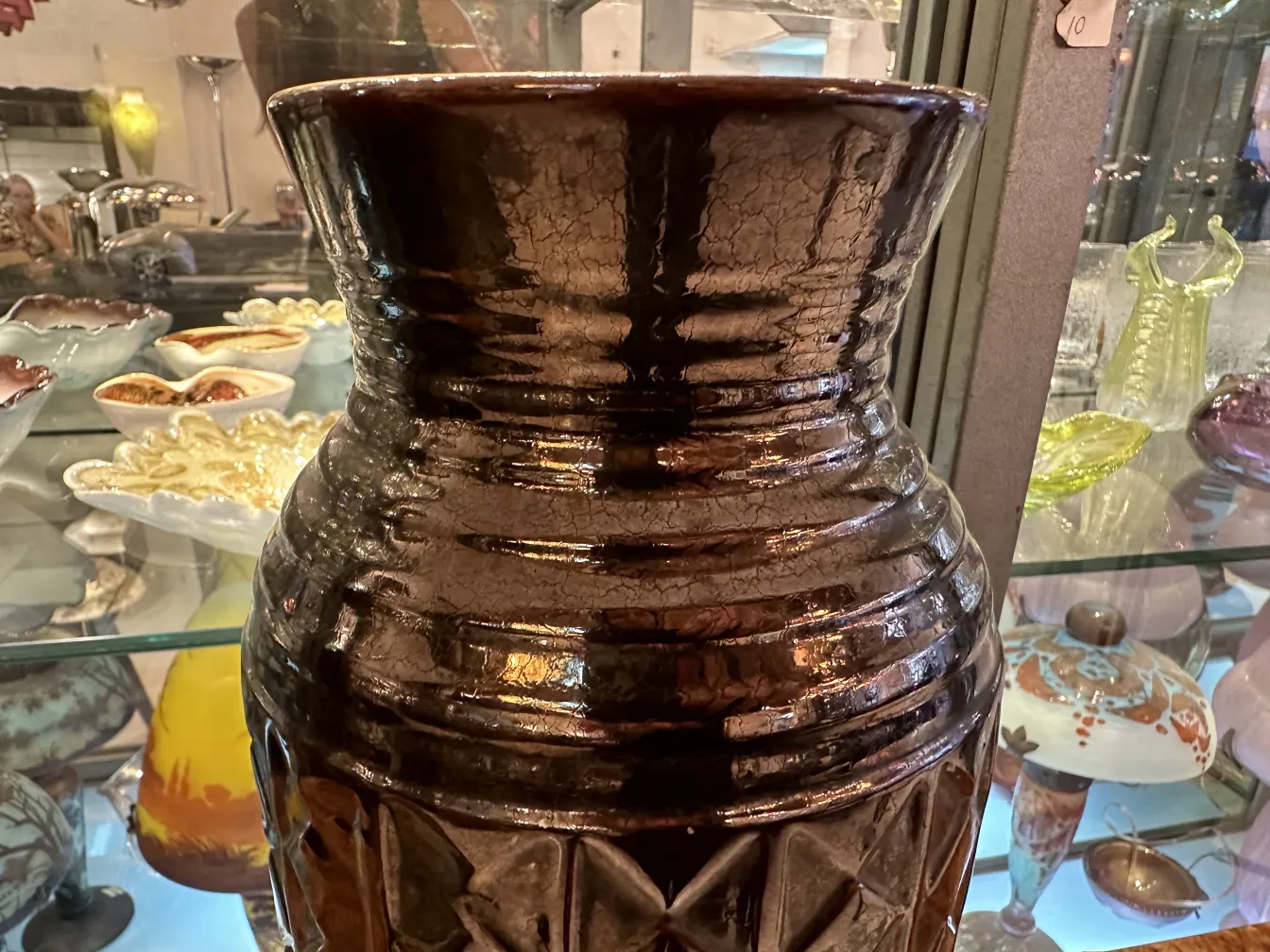 Vaso de cerâmica antiga com acabamento brilhante e detalhes artísticos.