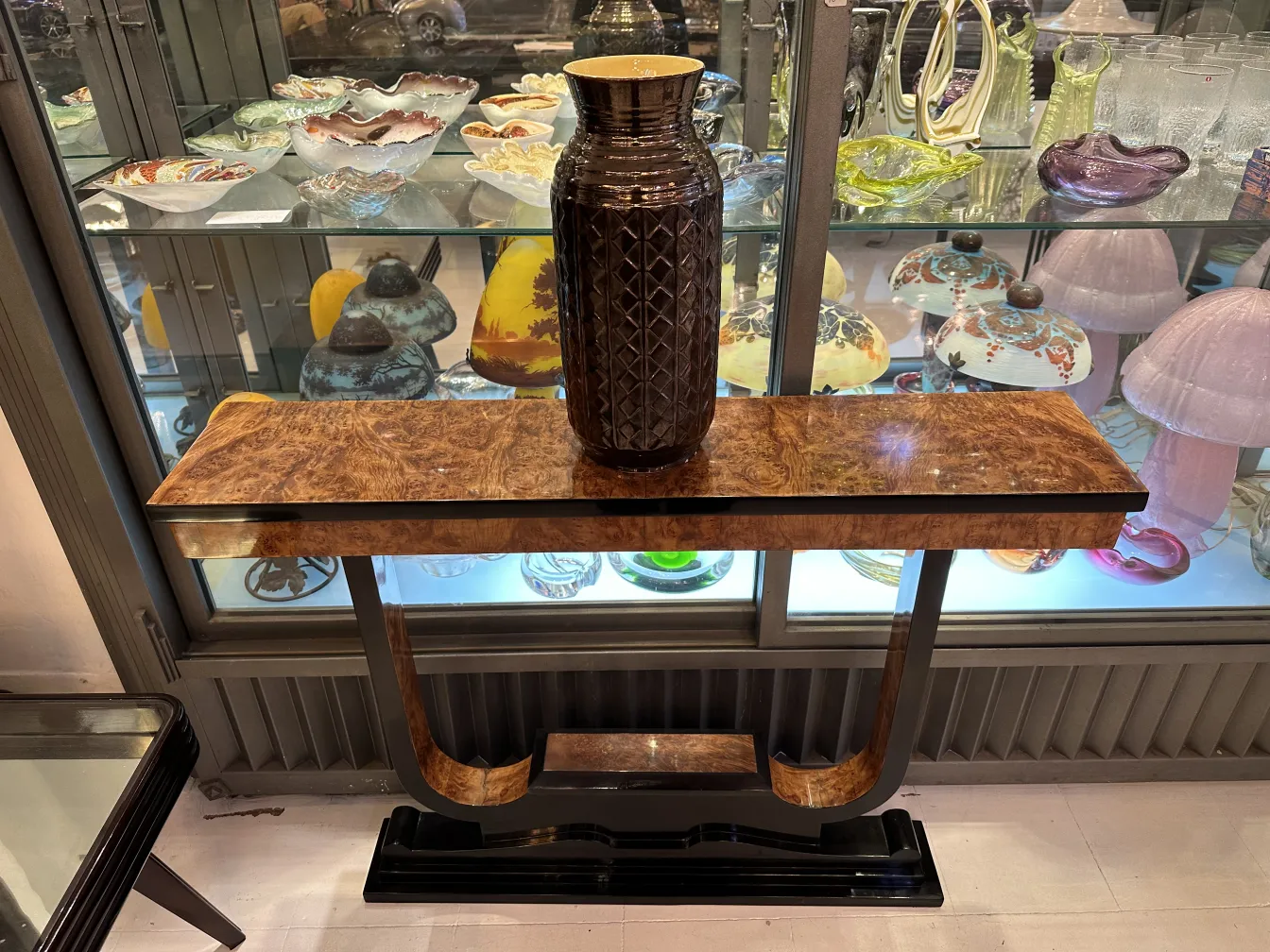 Table de console décorative avec un vase en céramique ancien exposé.