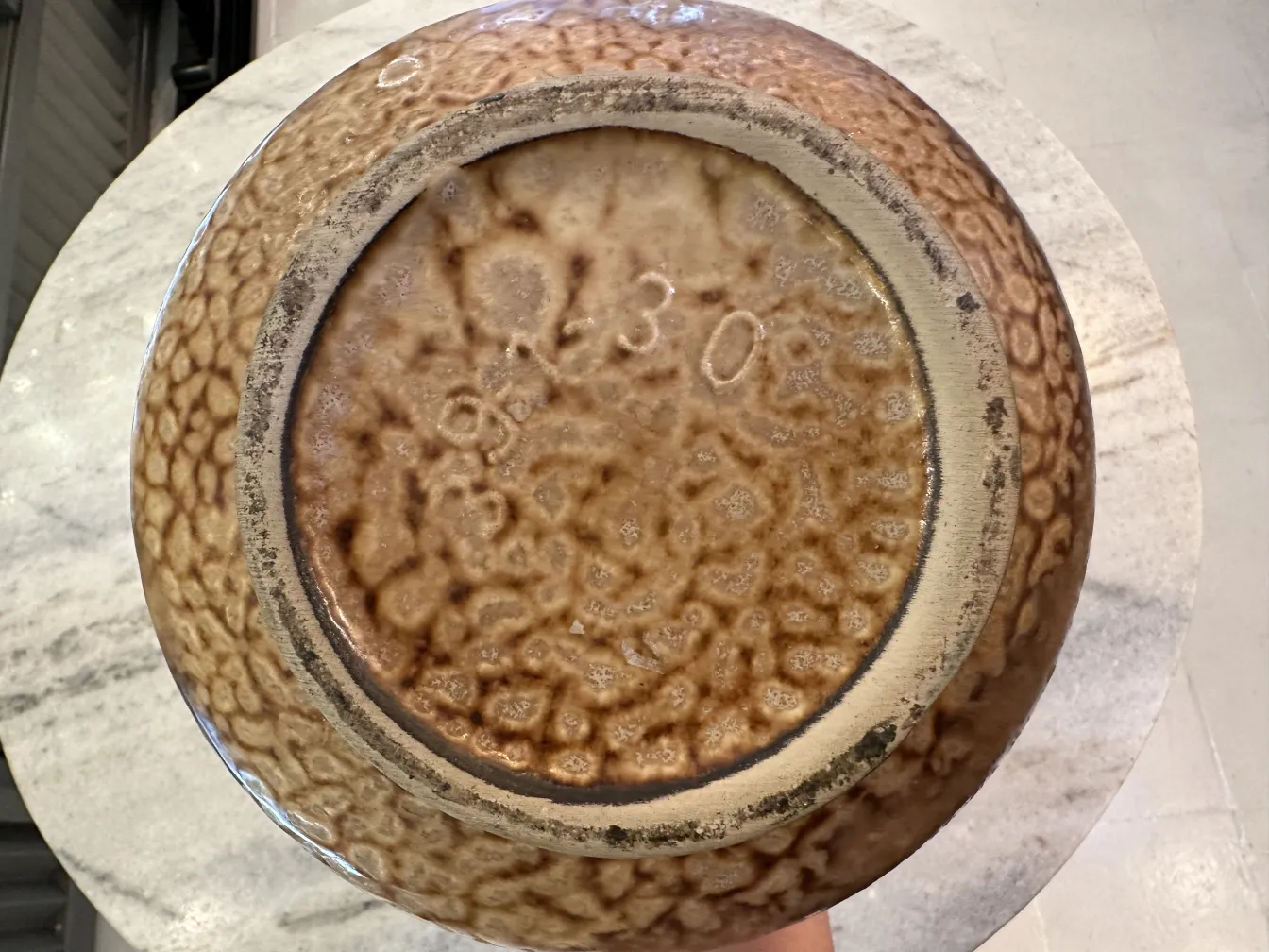 Tazón de cerámica antigua con textura marrón en relieve.