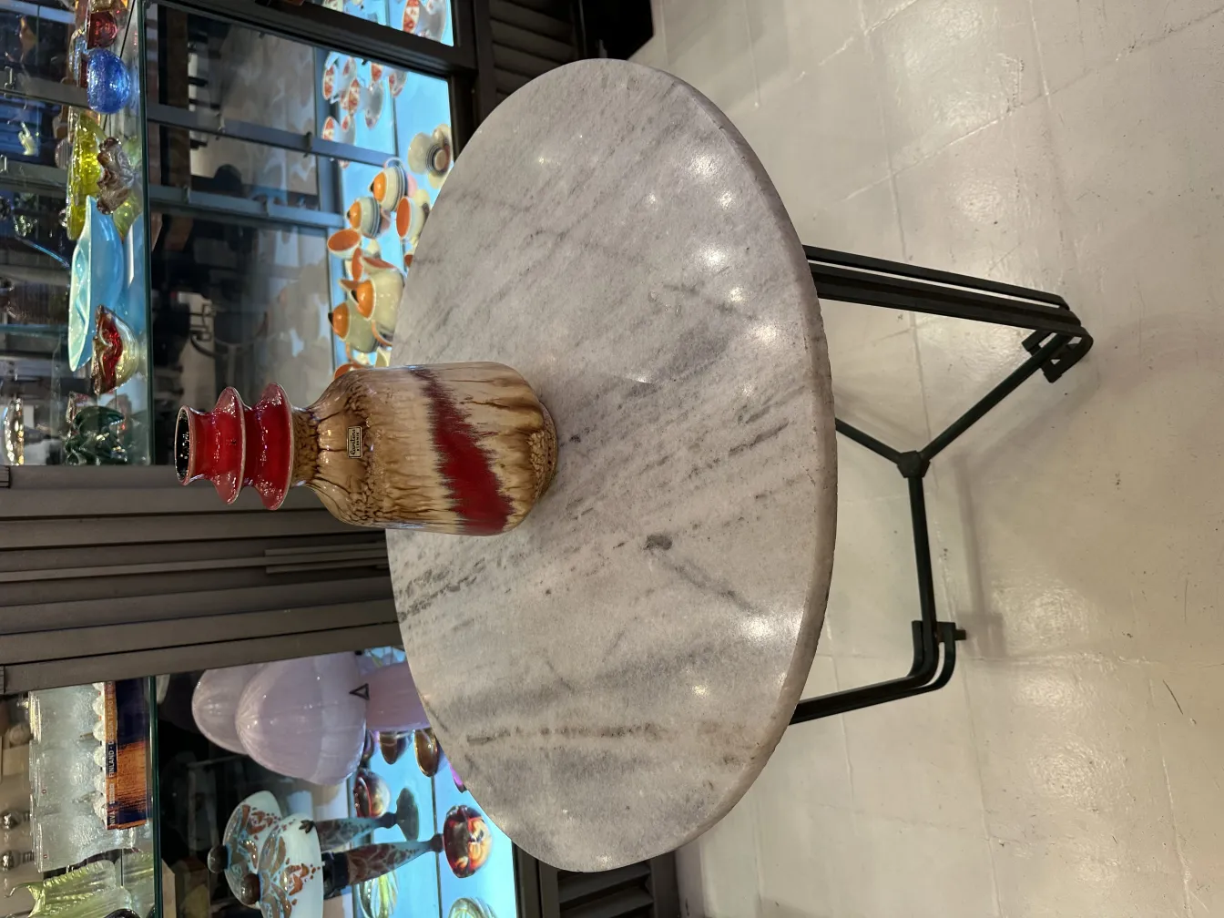 Antique ceramic vase with red details, displayed on a table.