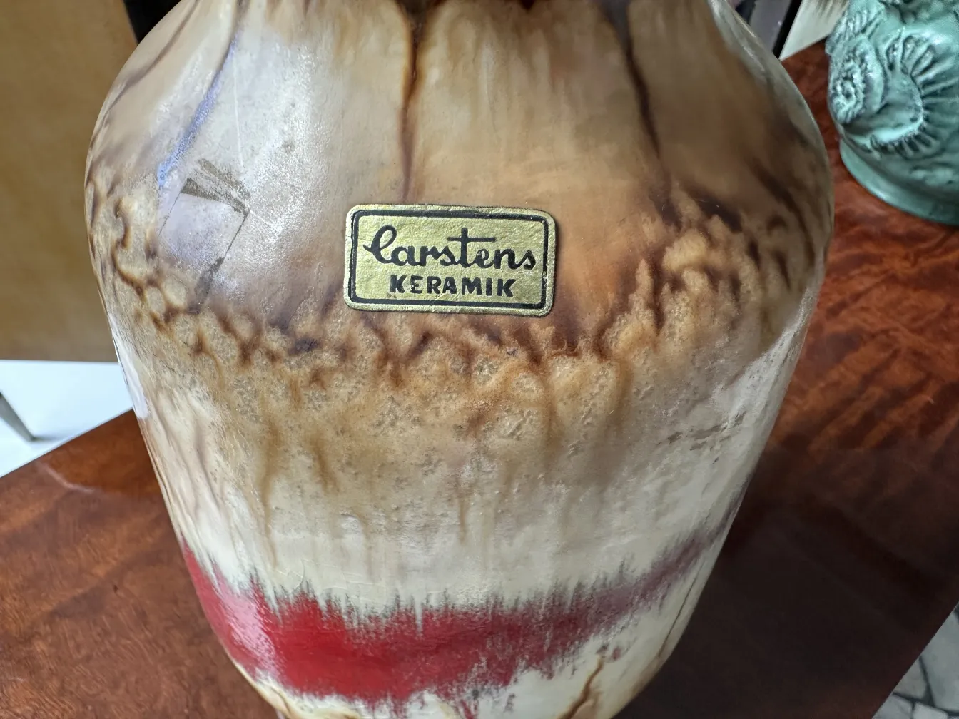 Vaso de cerâmica antiga com tons marrons e vermelhos, decorativo.