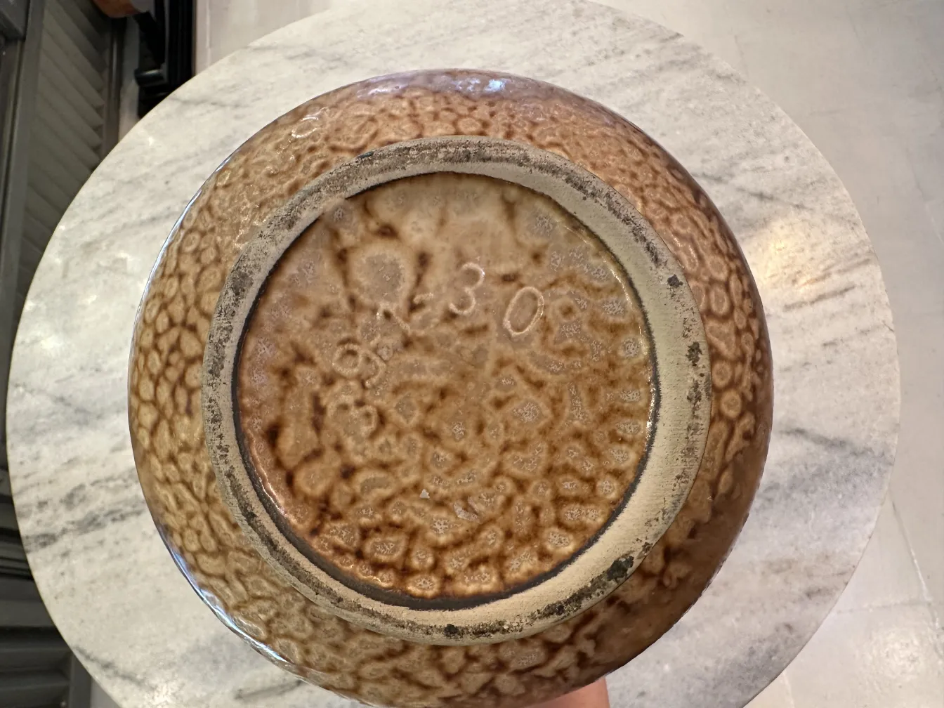 Ciotola in ceramica antica con texture ruvida e superficie lucida.