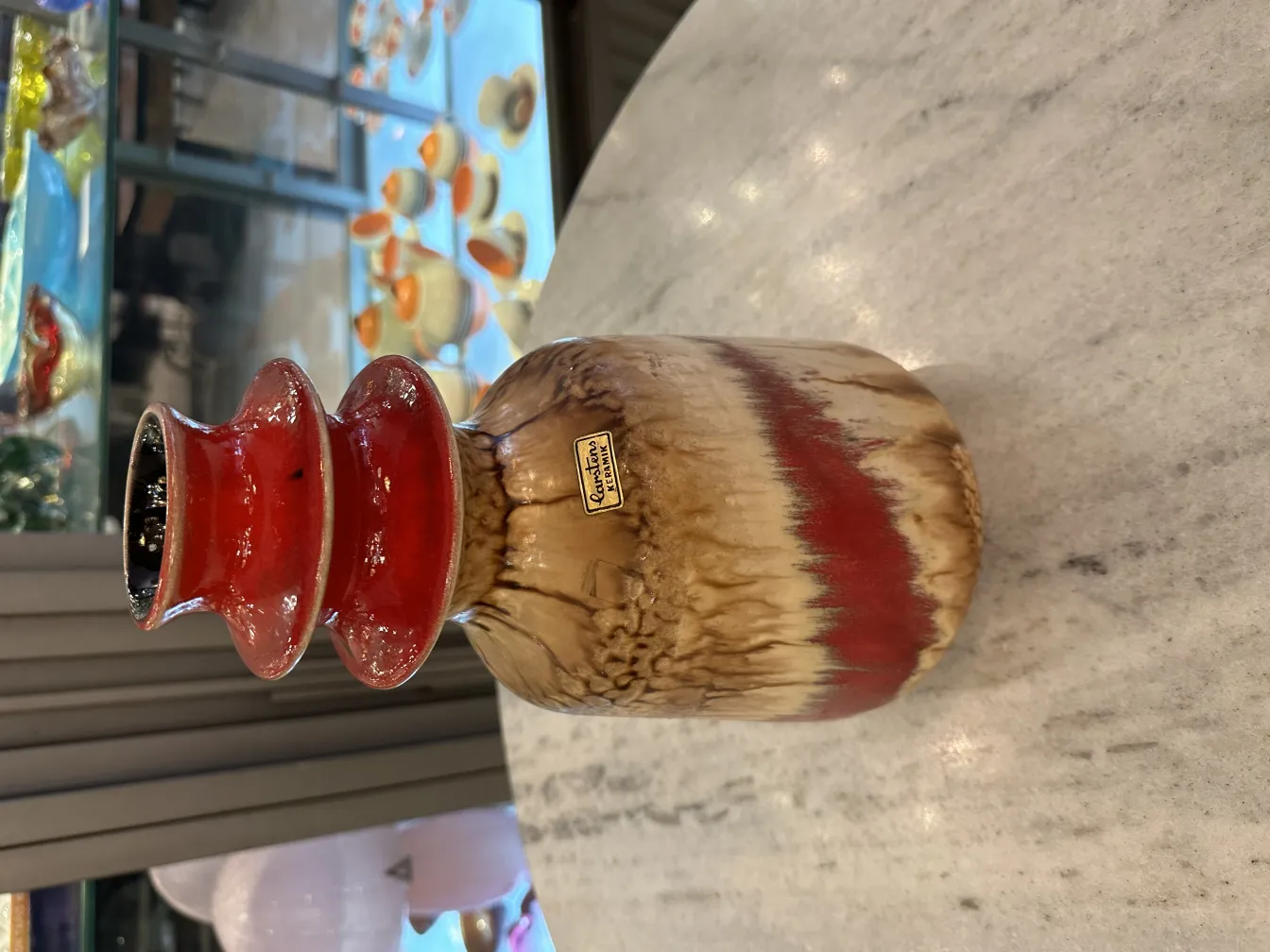 Jarrón de cerámica antigua con detalles en rojo y marrón, estilo único