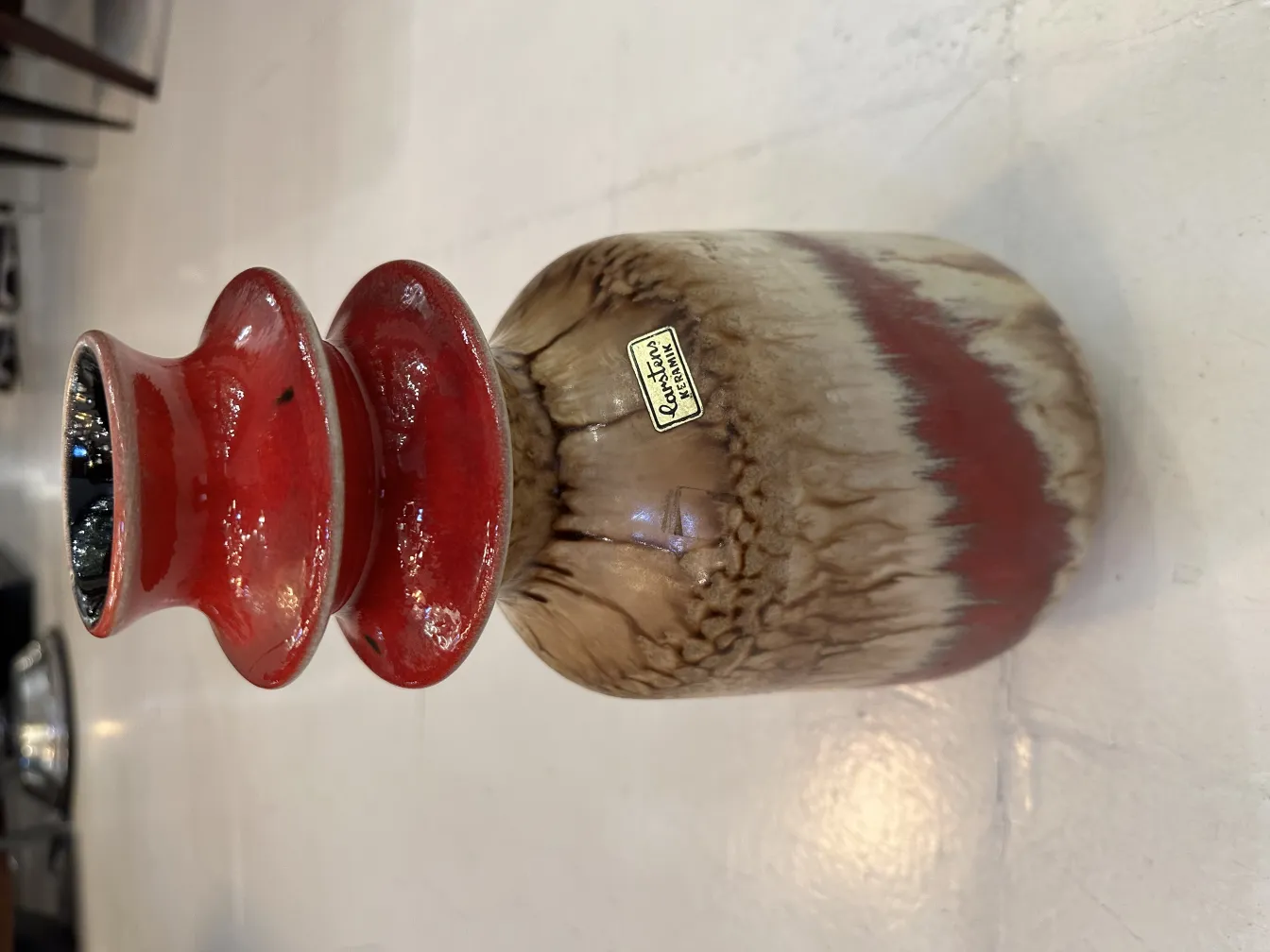 Antique ceramic vase with a red and beige finish.