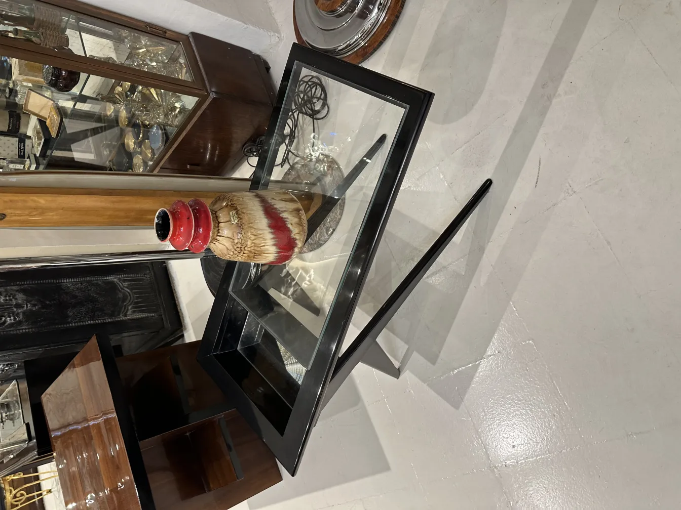 Vaso decorativo de cerámica antiga em uma mesa de vidro.