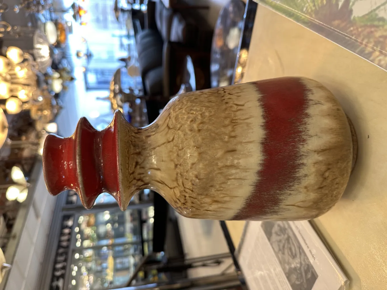 Vaso in ceramica antico con design decorativo in tonalità marroni e rosse.