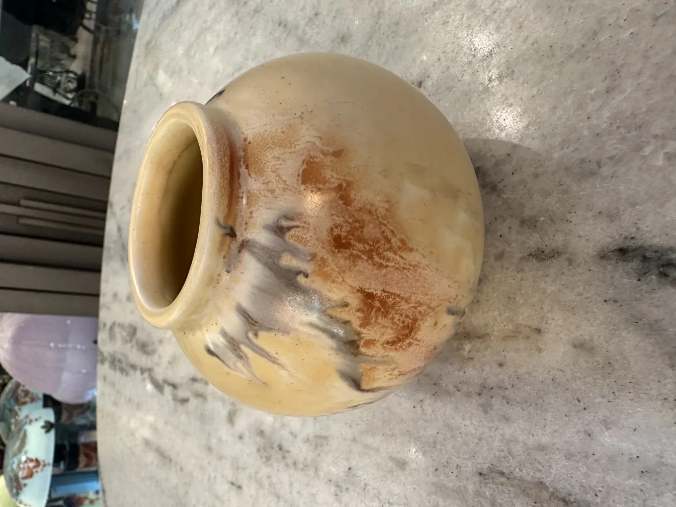 Vase ancien en céramique avec des tons terreux sur la table