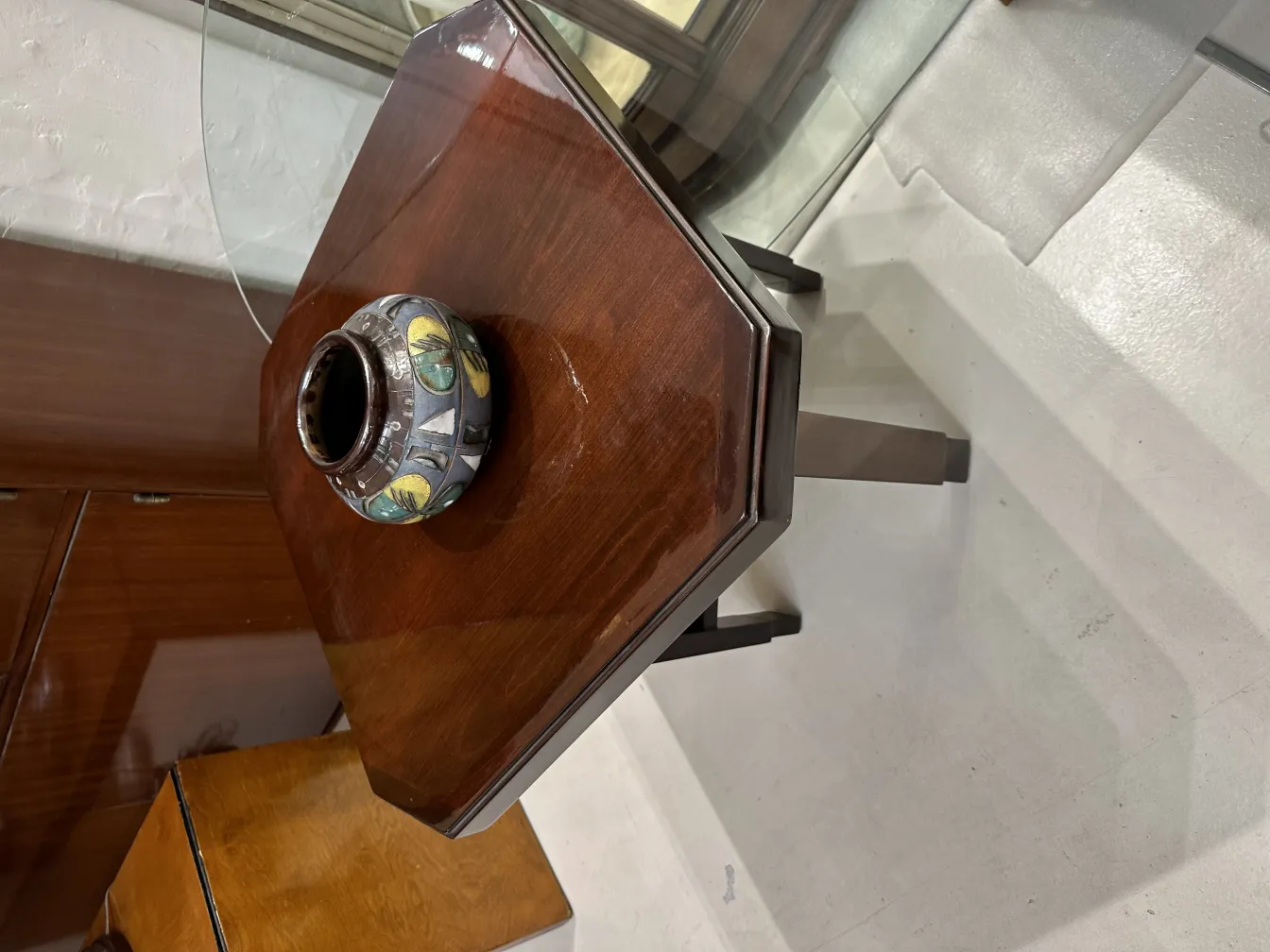 Antike Keramikvase mit buntem Design auf einem Holztisch