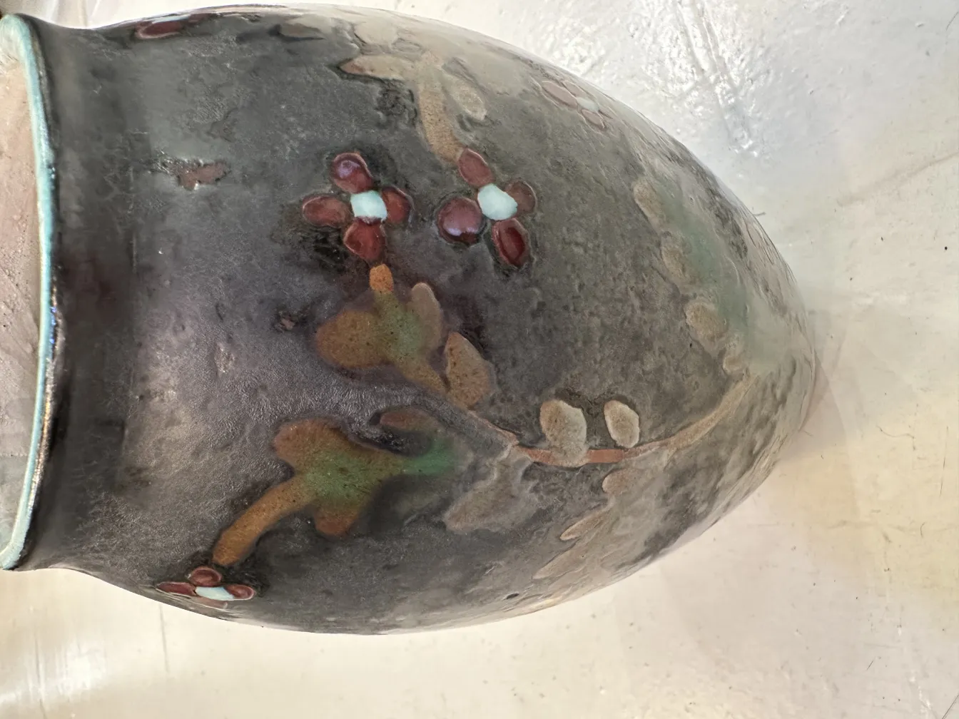 暗い色合いで花が装飾された古い陶器の花瓶。