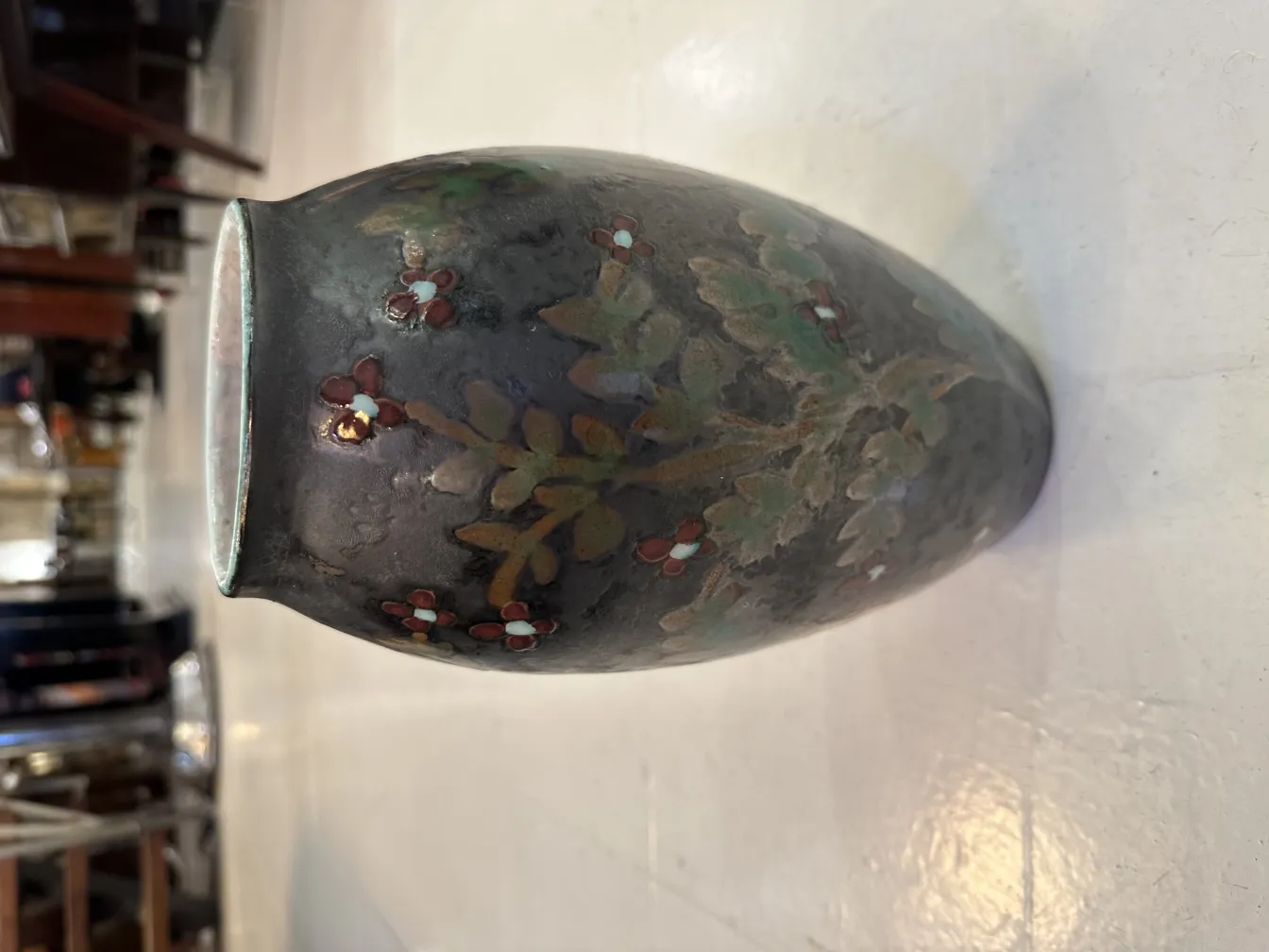 Vaso de cerâmica antiga com flores pintadas, fundo neutro