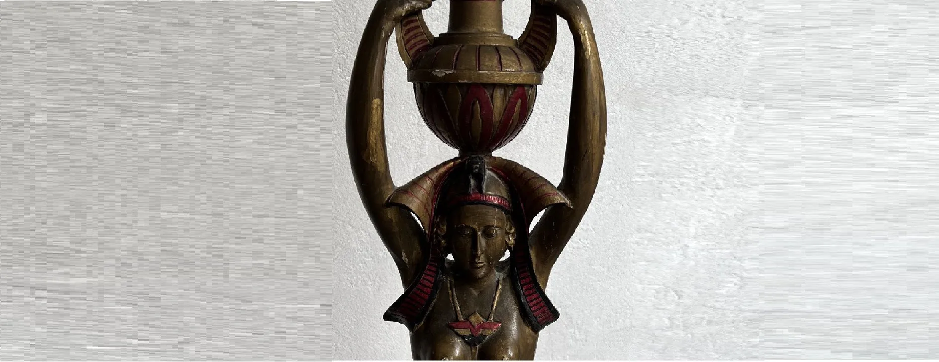 Escultura antigua de belleza con una figura femenina que sostiene un jarrón decorativo.