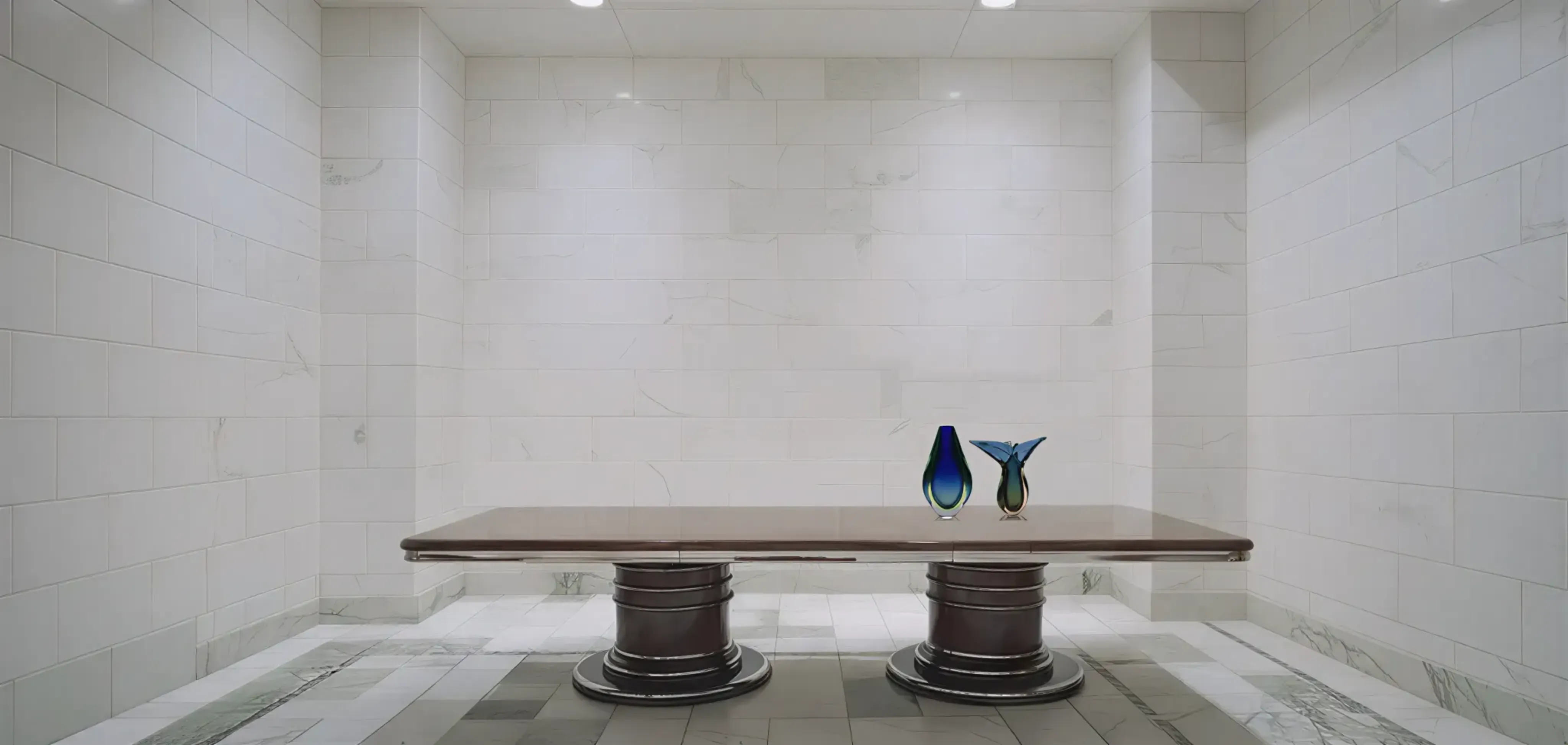 Floreros de Murano en varias formas y colores sobre una mesa elegante.