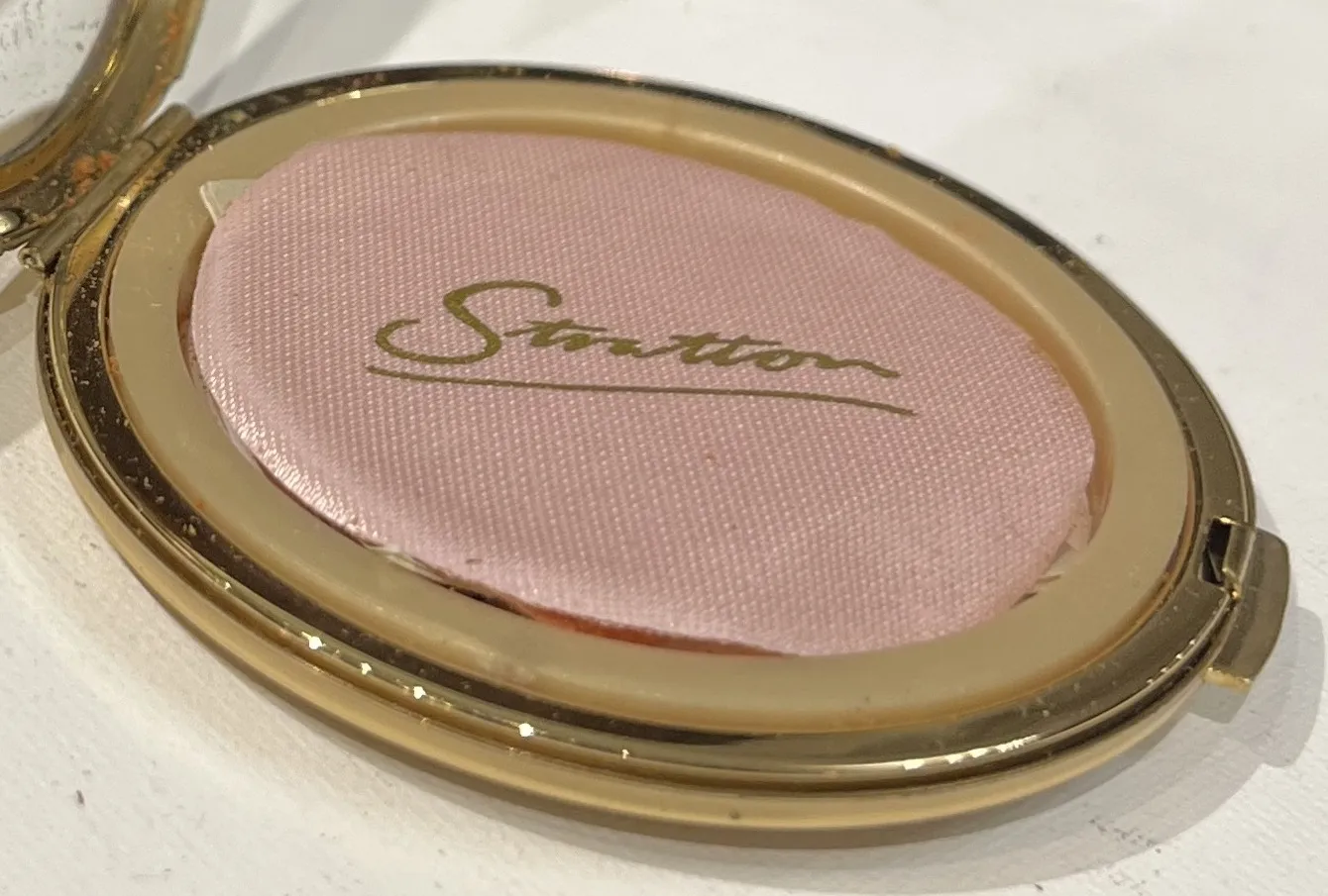 sello Stratton antiguo, con textura rosa y dorada