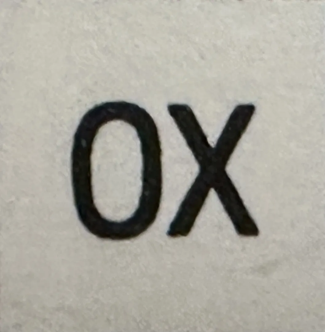 पुरातात्त्विक मुद्रण जिसमें 'OX' लिखा है, हल्का背景, प्राचीनता का एक उदाहरण।
