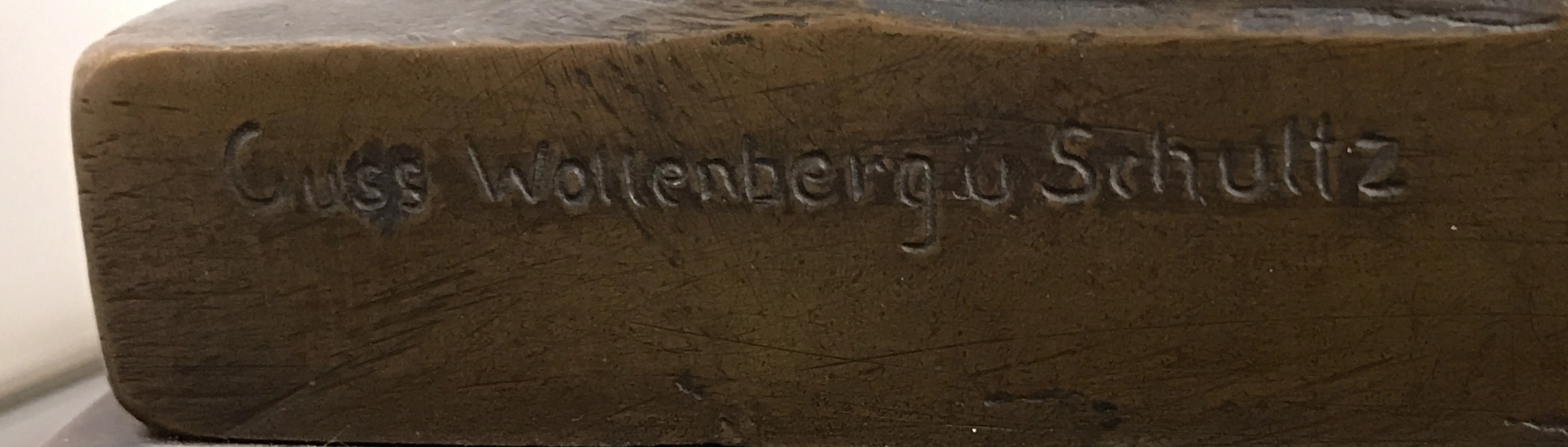 Sigillo antico Guss Wollenbergu Schuttz su sfondo neutro.